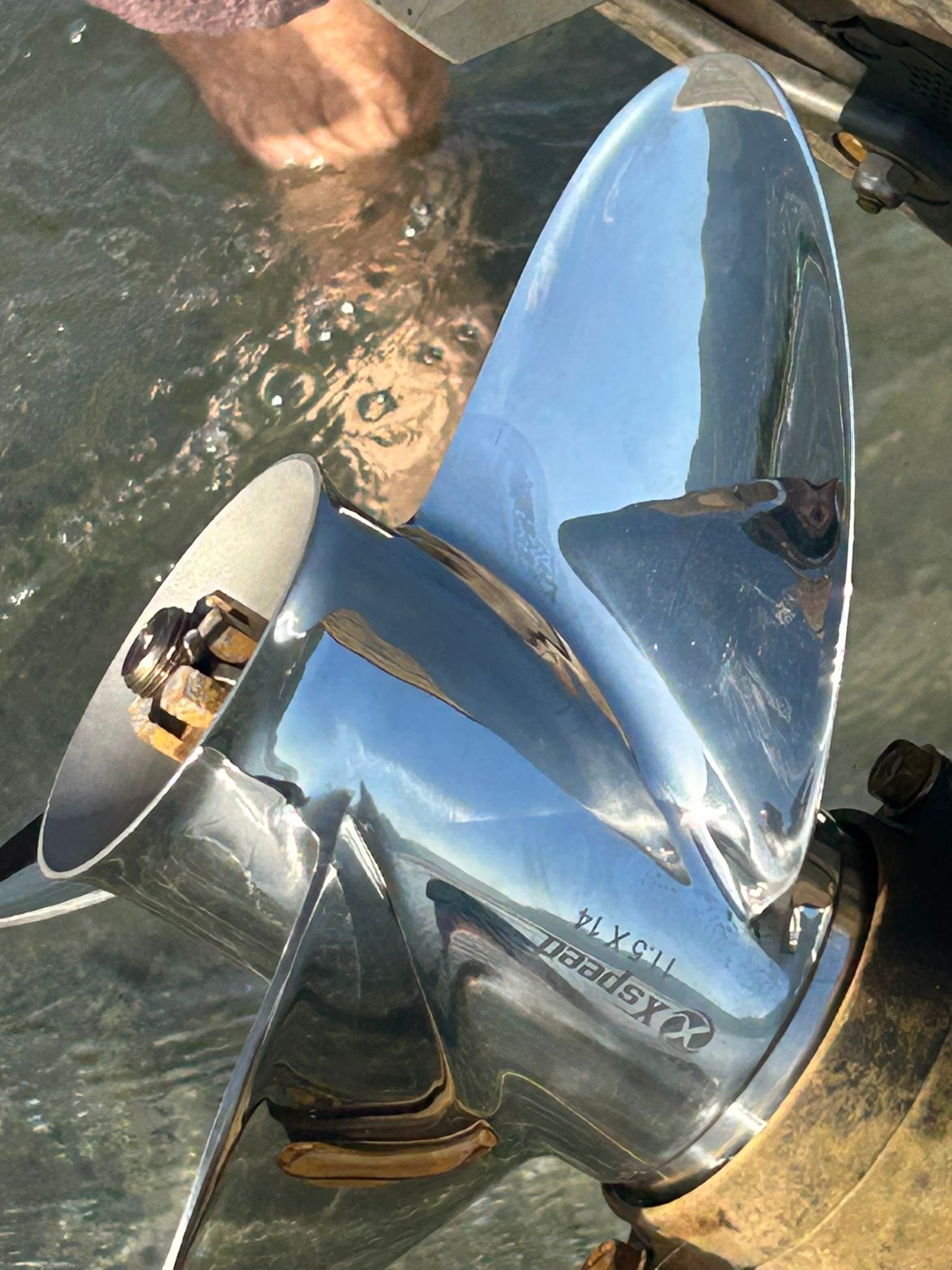 Close-up of the installed Xspeed stainless steel propeller on the Suzuki outboard