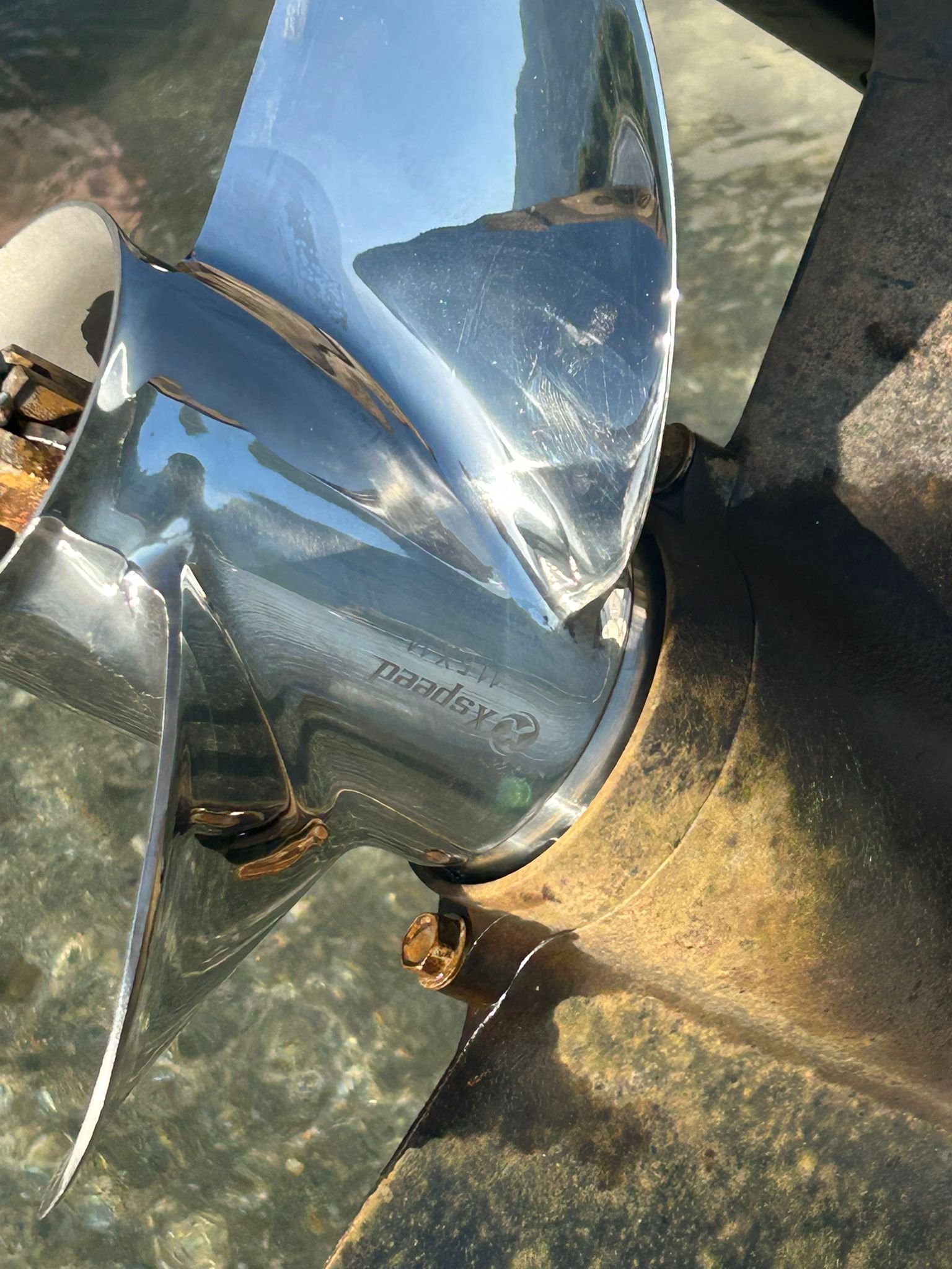 Xspeed three-blade stainless steel propeller installed on a Suzuki outboard lower unit